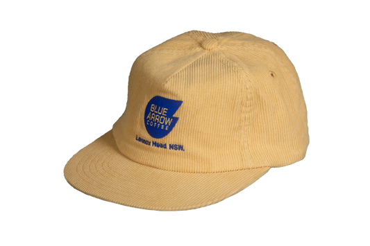 Beige cap with Blue Arrow Coffee logo on a white background